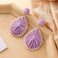 Close-up of earring hook and raffia weave pattern on teardrop shaped earrings