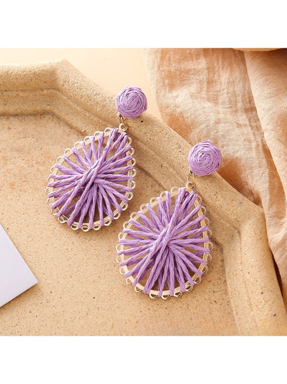 Close-up of earring hook and raffia weave pattern on teardrop shaped earrings