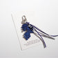 Keypus leaf shaped keychain shown in natural outdoor setting on a rock