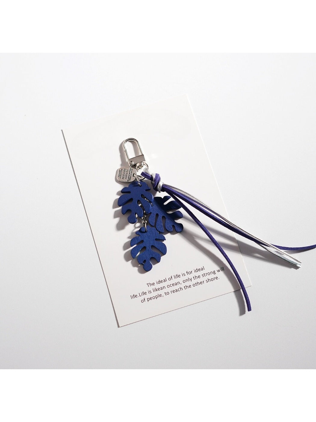 Keypus leaf shaped keychain shown in natural outdoor setting on a rock