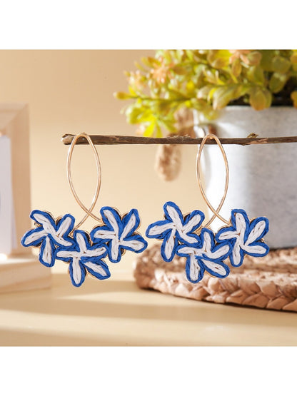 Pair of Earedge Sweet Flower Shaped Drop Earrings hanging from a jewelry stand