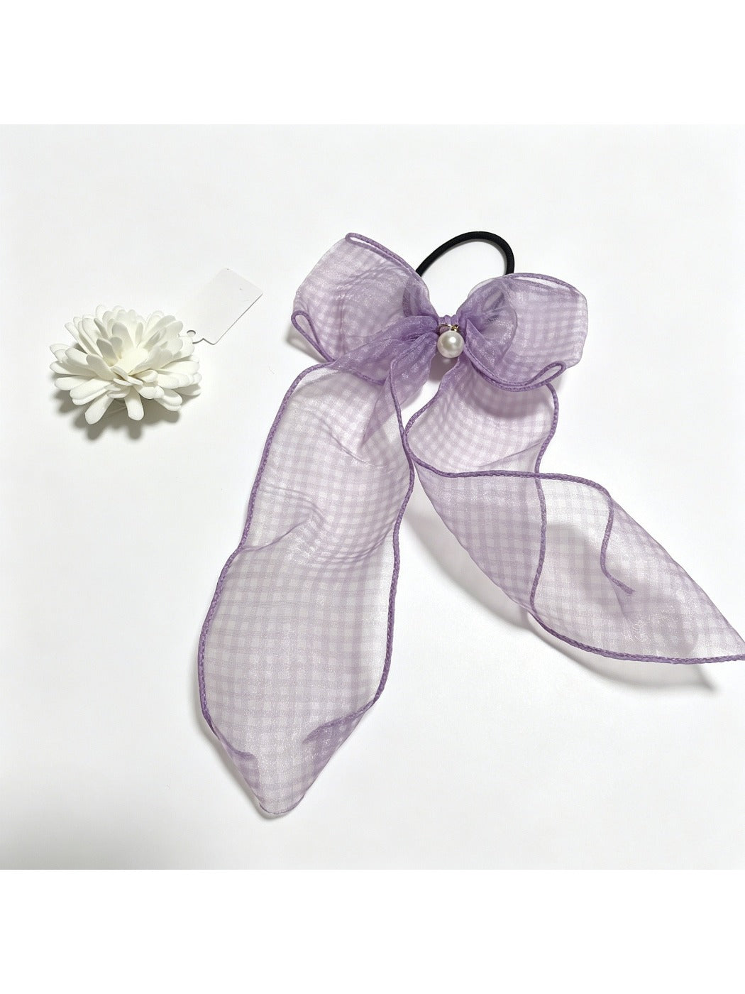 Side view of plaid tulle bow hair tie highlighting bow shape and elastic band