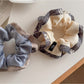 Close-up of Gifty ruffle scrunchie showing fabric texture and color block design