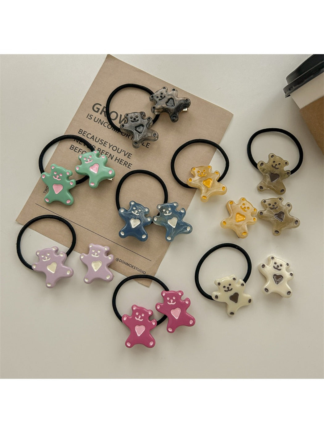 Hand holding a rose hair tie showing its elastic band and flower design