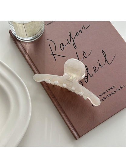 Beau acetate claw clip displayed open to show inner teeth and grip