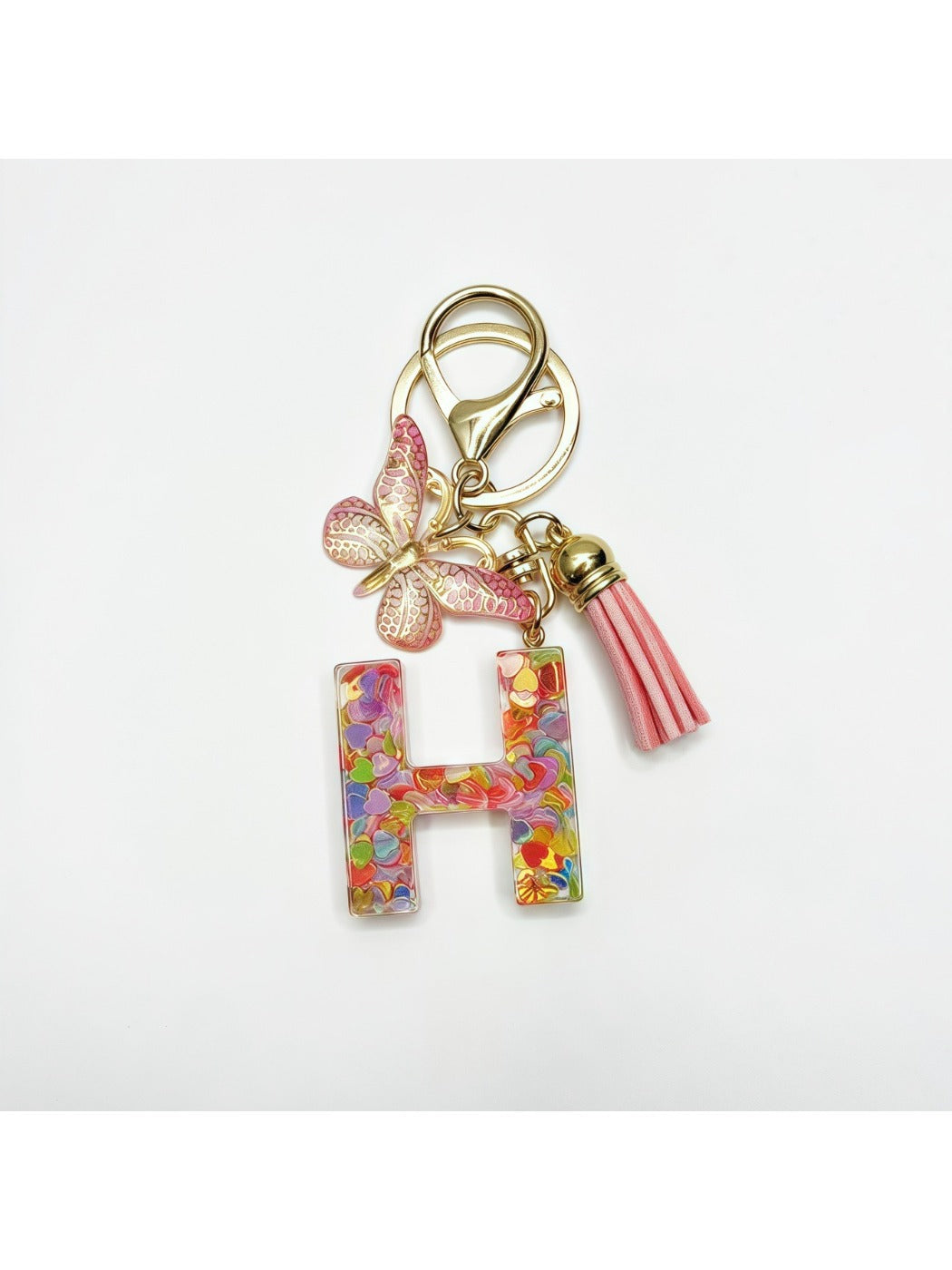 Keychain with butterfly and letter pendant resting on a leather wallet
