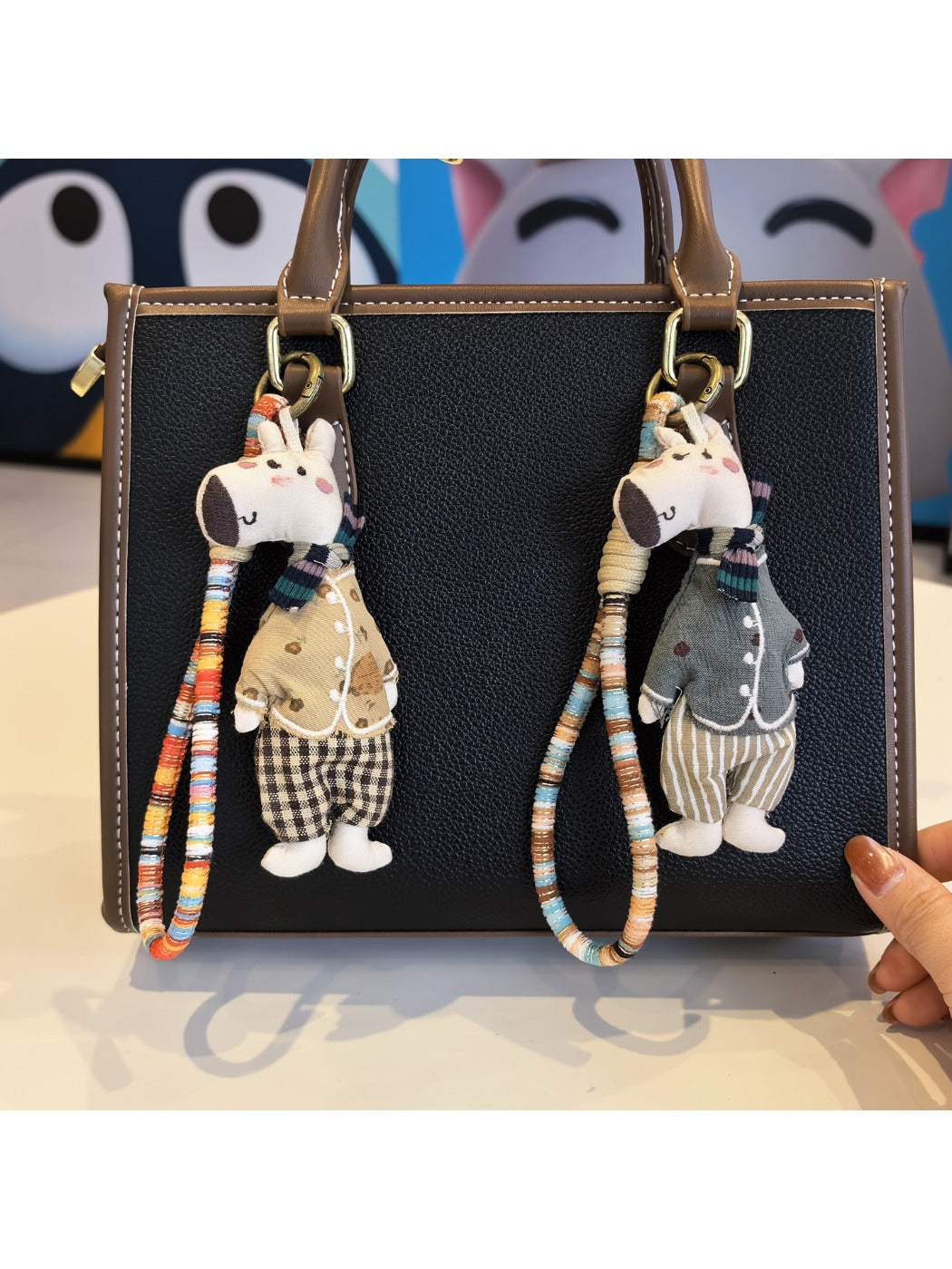 Close-up of a stylish giraffe charm keychain with gold and brown enamel details