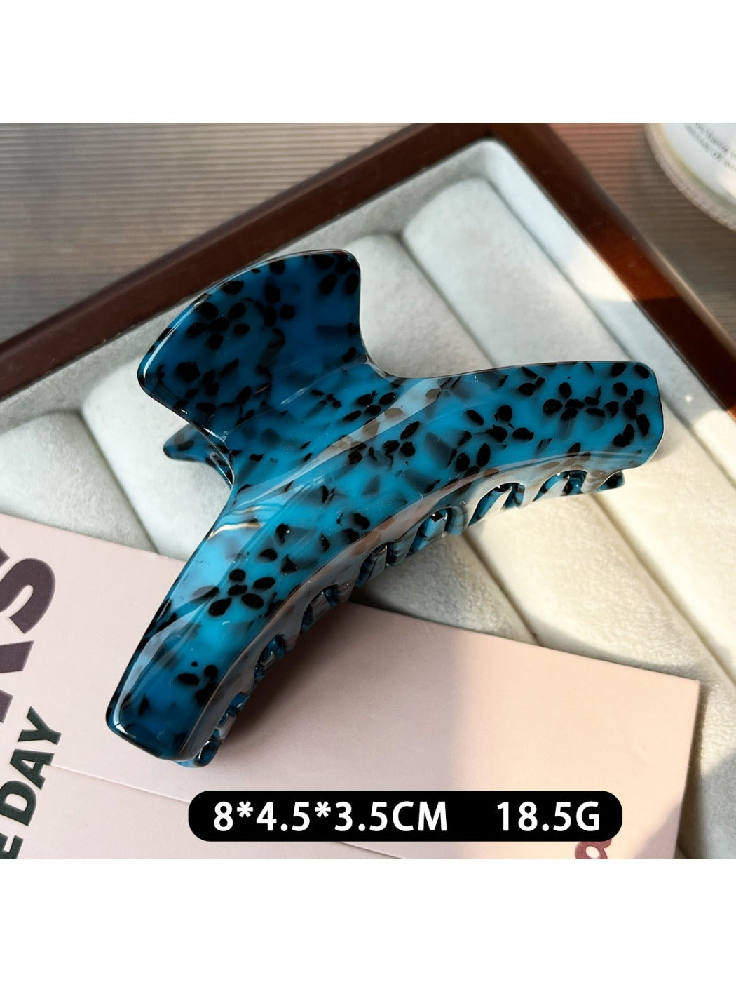Beau claw clip placed on a wooden surface with natural lighting