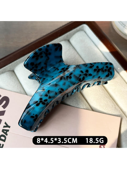 Beau claw clip placed on a wooden surface with natural lighting