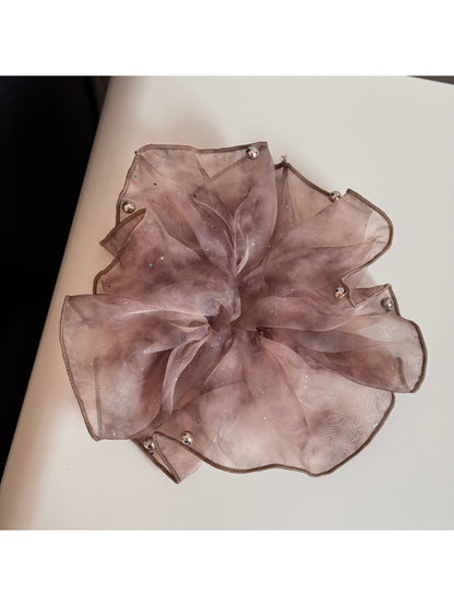 Pink sparkly tulle scrunchie displayed on a white background