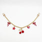 Cherry charm hanging from a set of keys with a blurred background