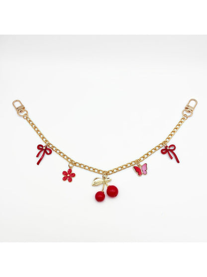 Cherry charm hanging from a set of keys with a blurred background