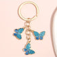 Butterfly keychain attached to a set of keys on a wooden surface