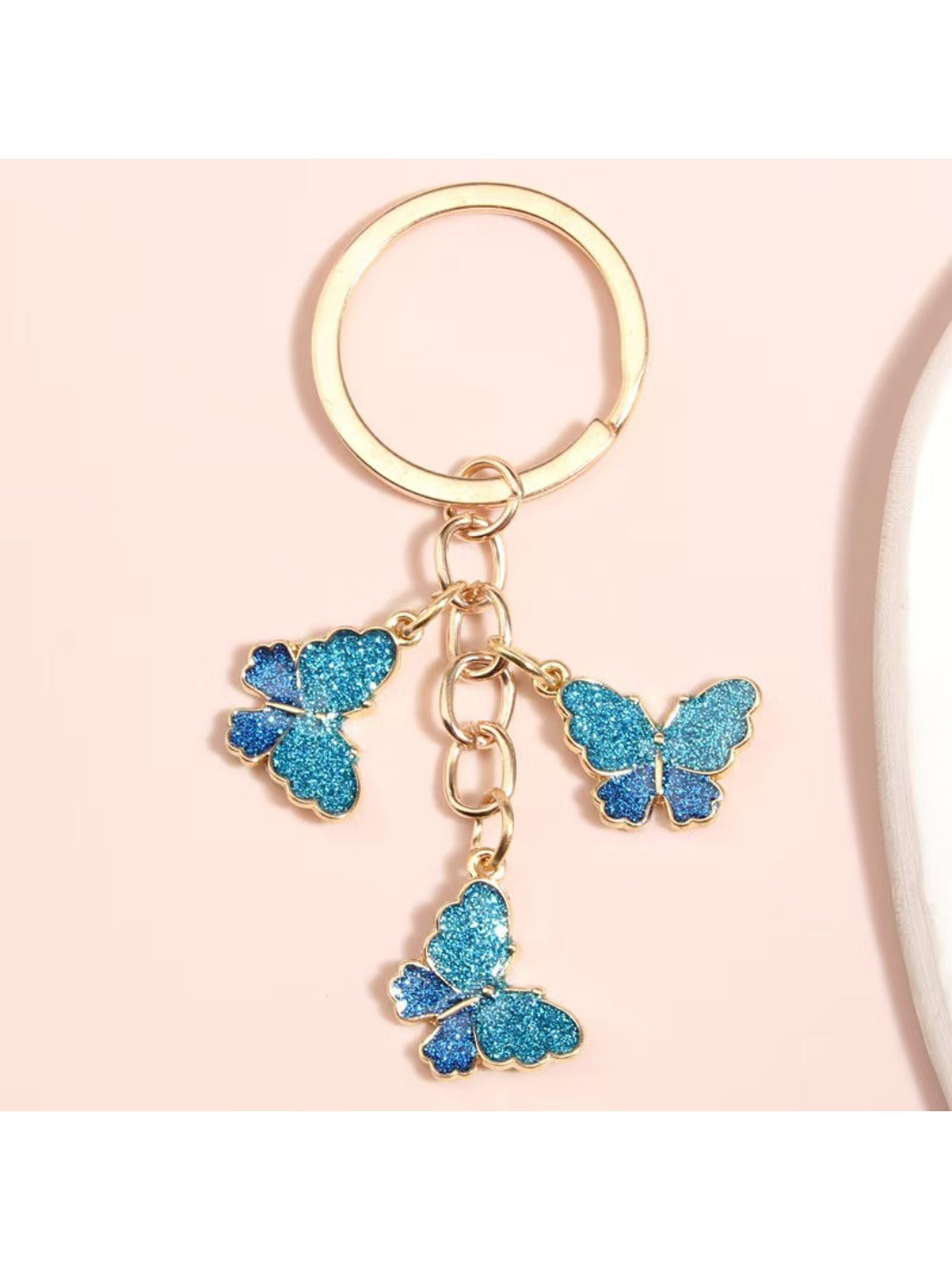 Butterfly keychain attached to a set of keys on a wooden surface