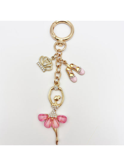 Ballerina charm keychain placed on a white surface with soft lighting