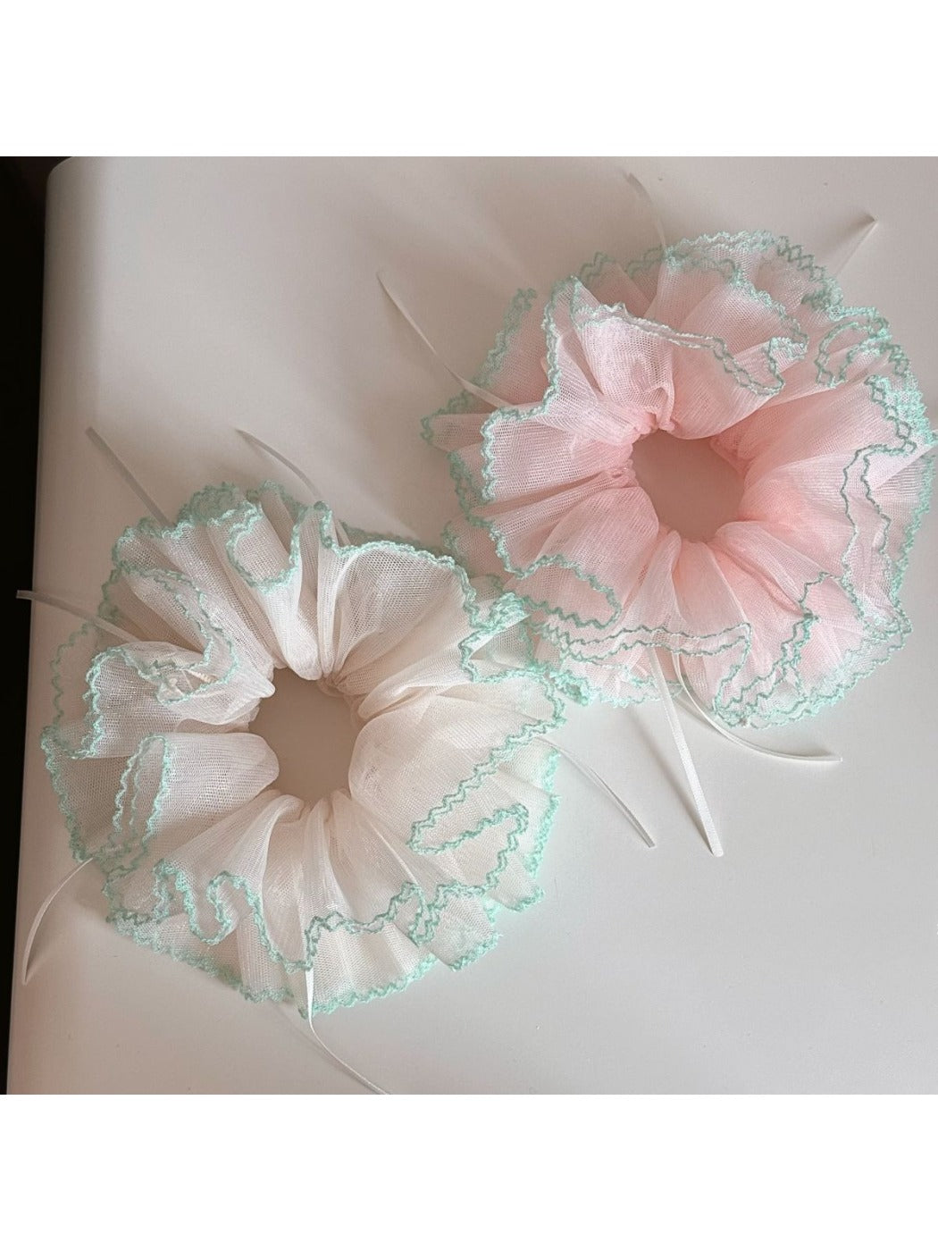 Gifty Ribbon Knot Tulle Scrunchie worn on a model's wrist with casual outfit