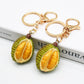 Close-up of a lifelike durian shaped keychain with textured green and yellow surface