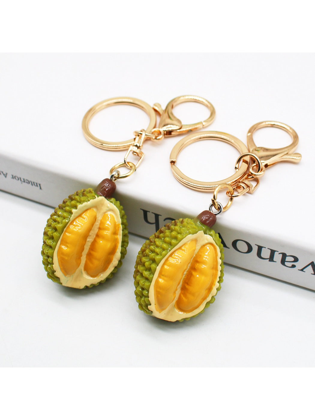 Close-up of a lifelike durian shaped keychain with textured green and yellow surface