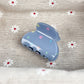 Beau hair claw clip with blue star design next to matching accessories