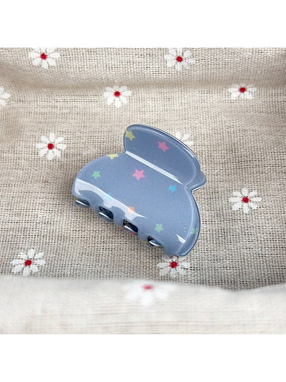 Beau hair claw clip with blue star design next to matching accessories