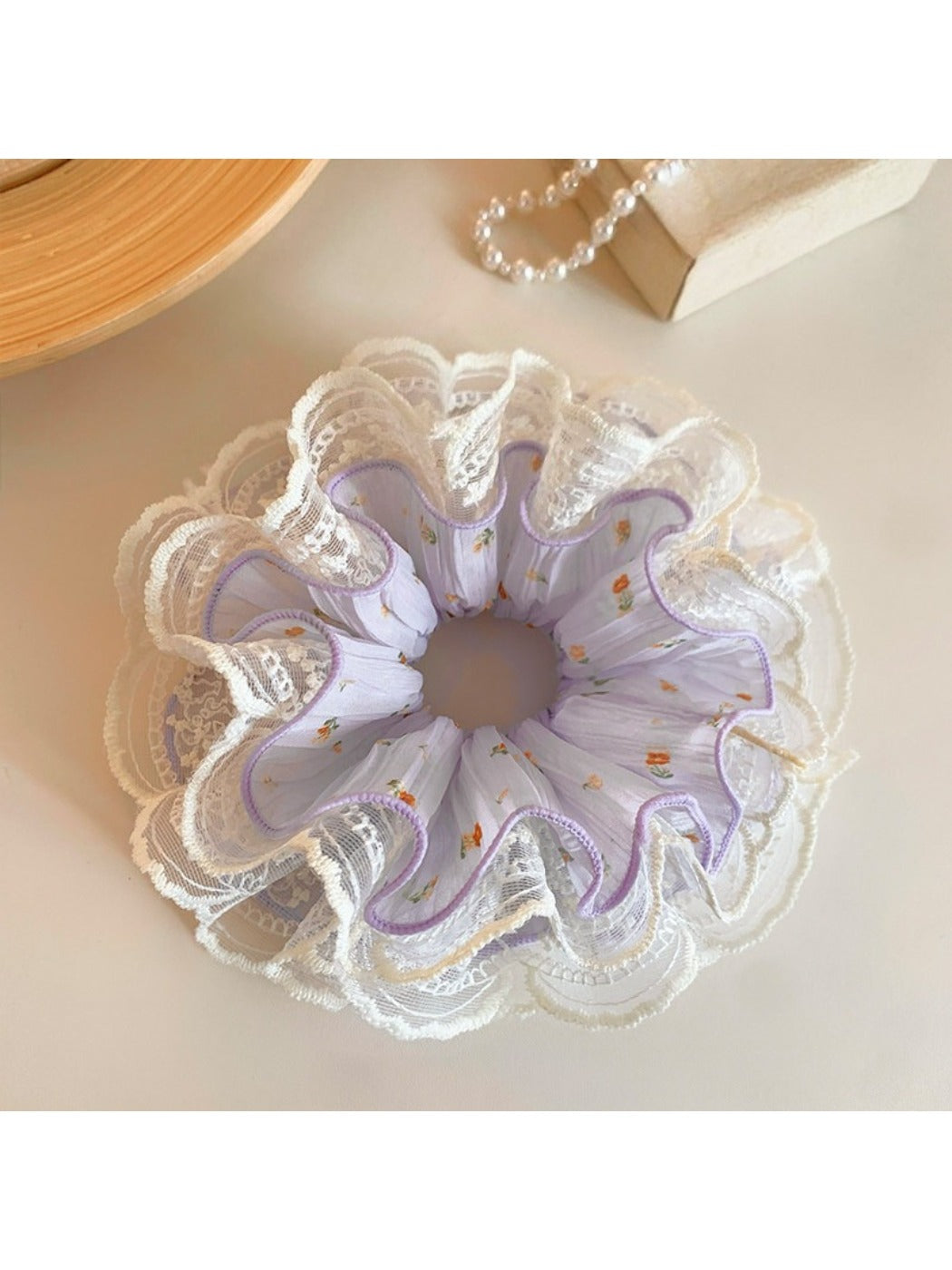 Purple scrunchie styled in a ponytail on a model with light hair