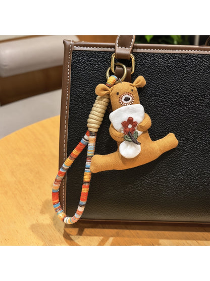 Bear keychain held in a hand displaying size and flower detail