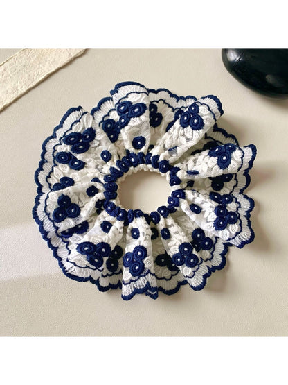 Gifty scrunchie worn on wrist showing vibrant design and soft fabric texture
