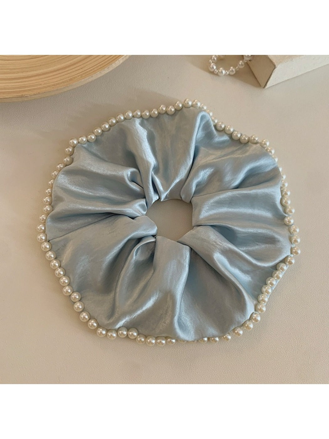 Gifty chic satin scrunchie with pearl beads shown from a side angle