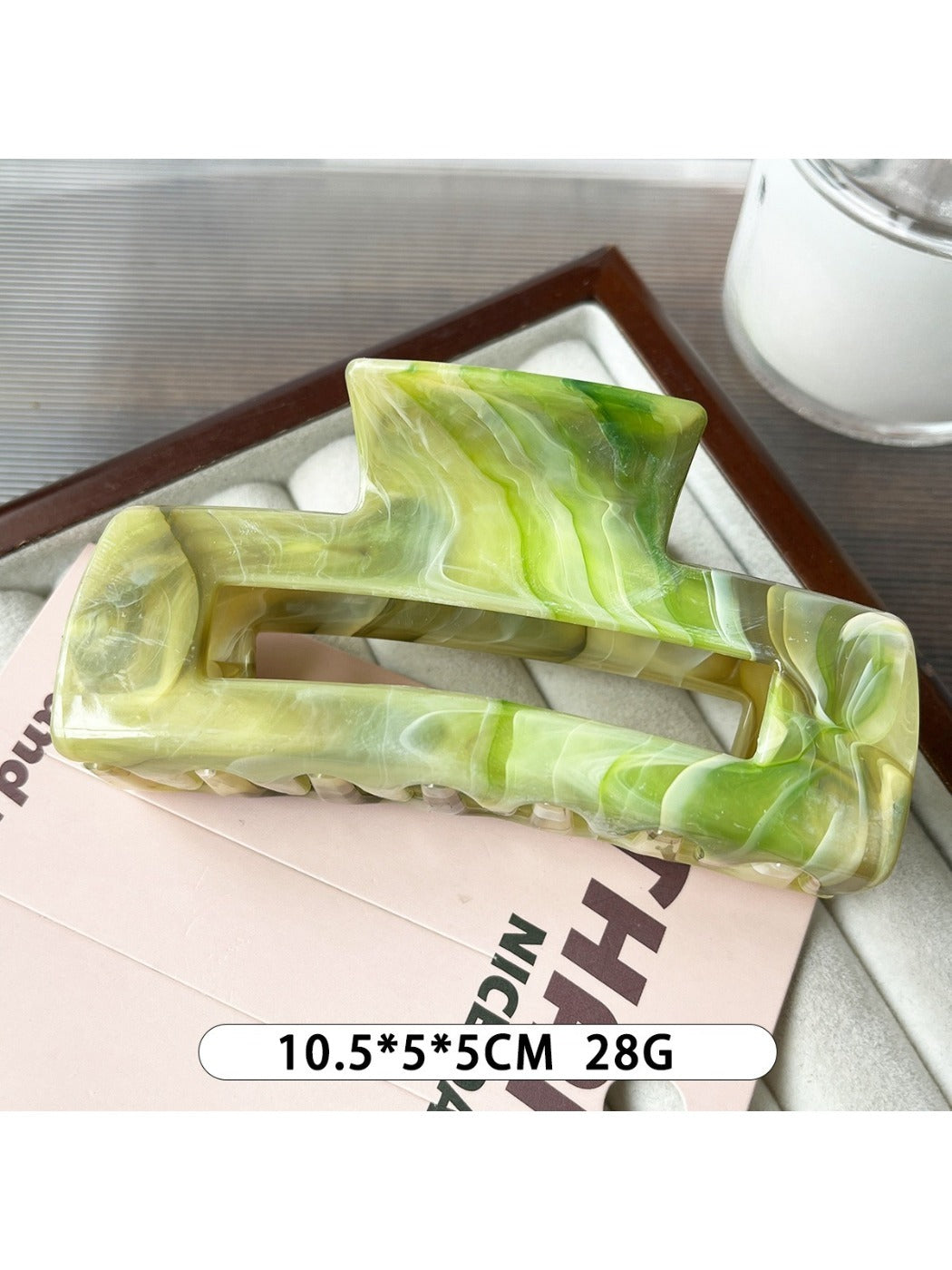 Beau marble pattern square claw clip resting on a wooden surface
