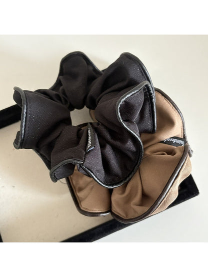 Set of multiple scrunchies in various pastel shades displayed on a white surface