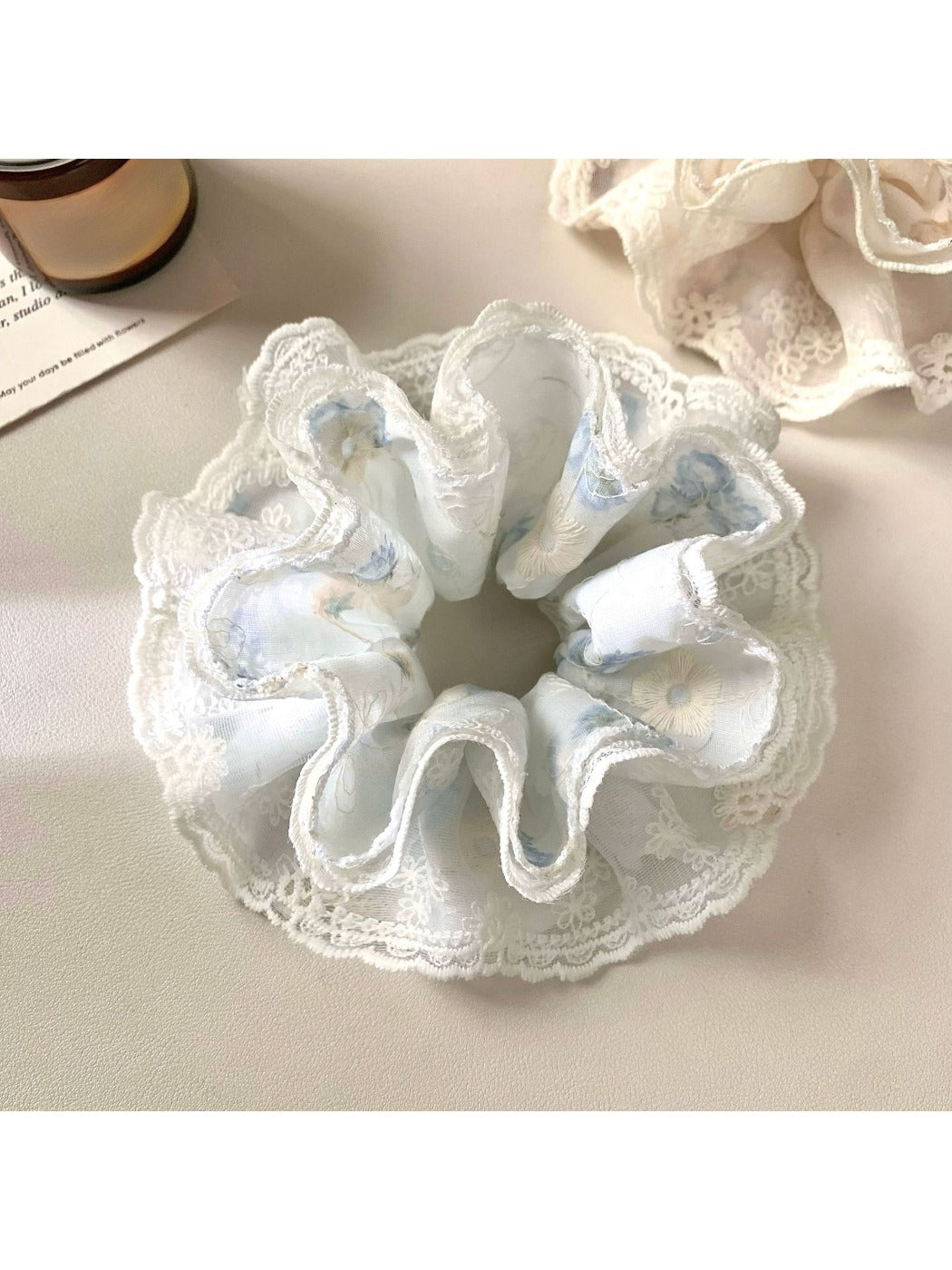 Close-up of Gifty scrunchie showing smooth fabric texture and monochrome pattern