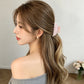 Pink floral hair claw clip in a half-up hairstyle