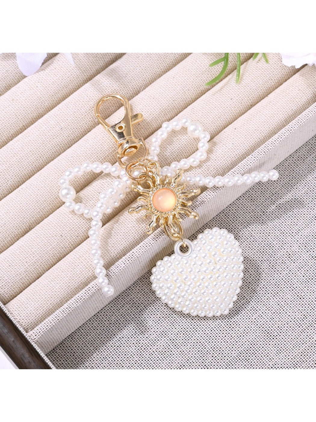 Pink bow heart shaped keychain with gold ring held in hand