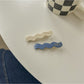 Beau hair clip with blue and white flowers against a plain white background