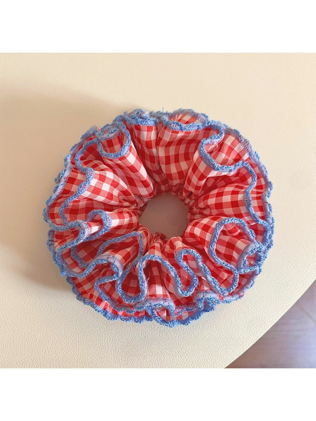 Red plaid scrunchie with ruffled fabric detail on a white background