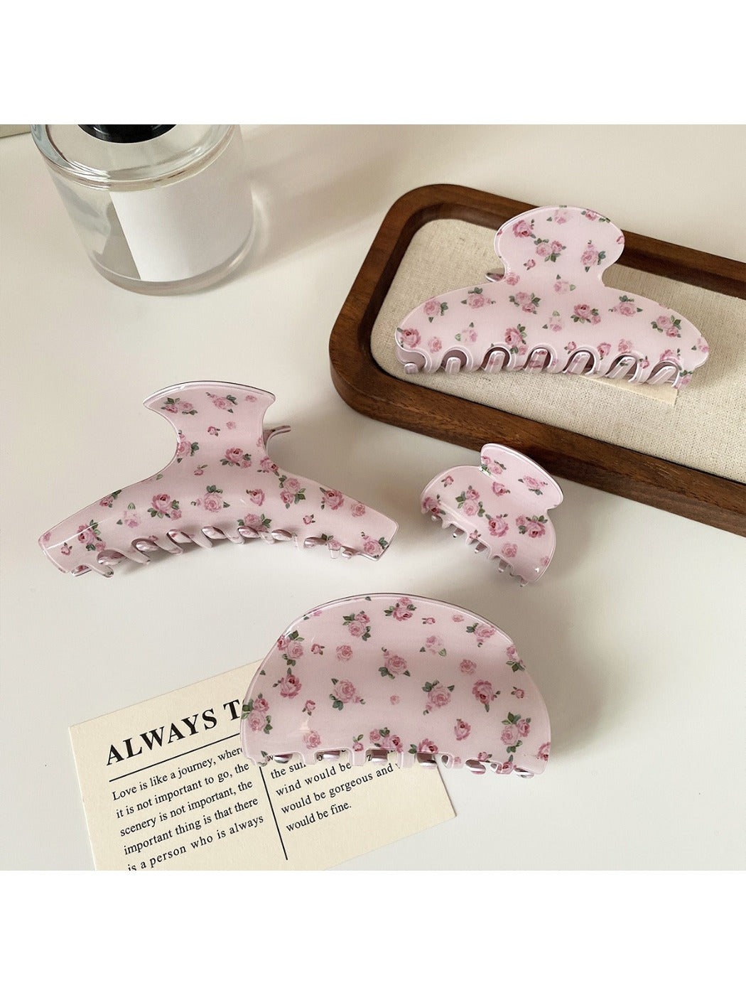 Close-up of Beau hair claw clip with pink rose pattern and curved teeth