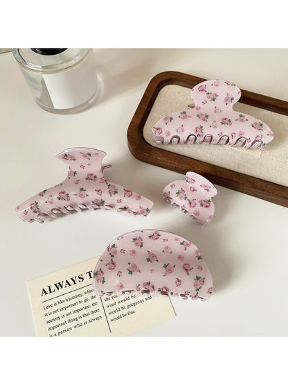 Close-up of Beau hair claw clip with pink rose pattern and curved teeth