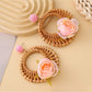 Vintage rattan woven circle earrings placed on wooden surface