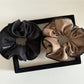 Scrunchie wrapped around a ponytail on a model with smooth hair