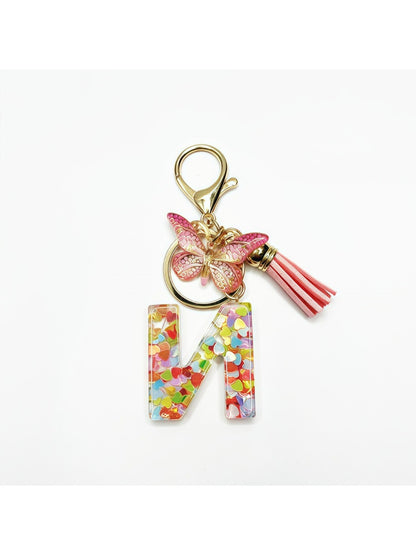 Close-up of silver letter pendant with butterfly charm on keyring