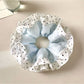 Gifty scrunchie displayed flat highlighting the circular shape and vibrant color blocks