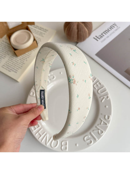 Gifty hair clip held in hand showing size and minimalist beige fabric design