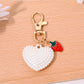 Red heart shaped bag charm keychain with embossed logo detail on leather