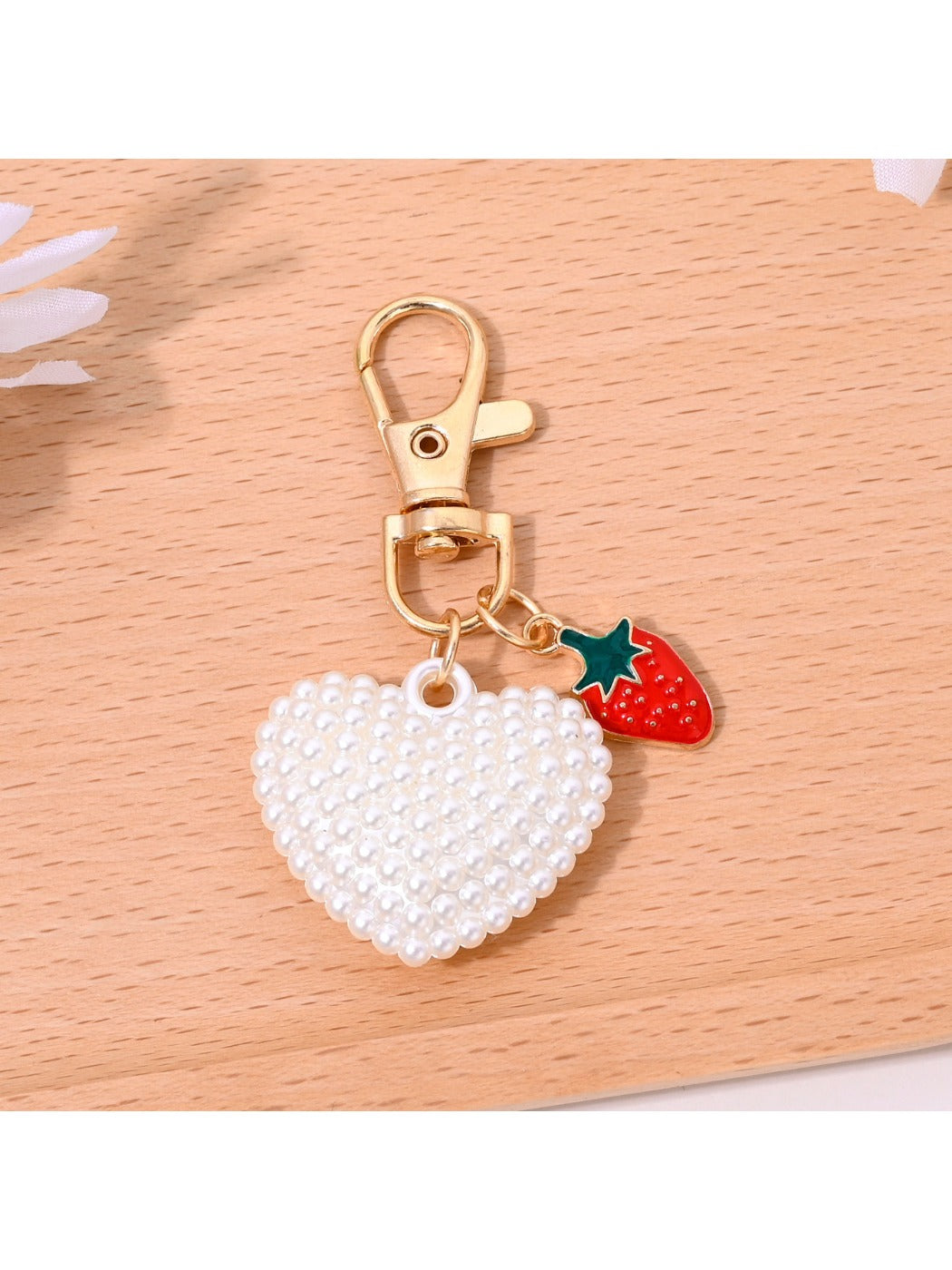 Red heart shaped bag charm keychain with embossed logo detail on leather