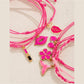 Close-up of lipstick bow-shaped pendant on Lovra woven bracelet
