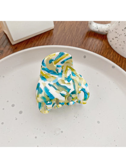 Beau half moon claw clip with vibrant multicolor design on neutral background