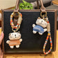 Trendy cat charm keychain hanging from a hand with blurred background