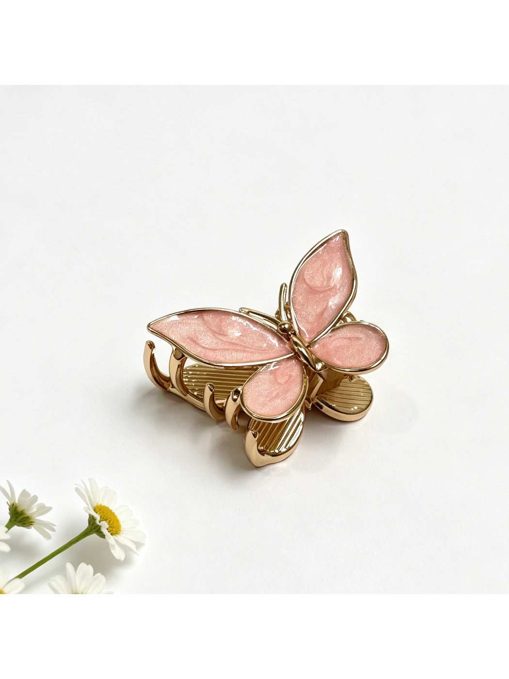 Beau butterfly hair clip in pastel yellow held in hand to show size