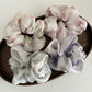 Close-up of Gifty satin hair scrunchie with colorful floral print on a white background