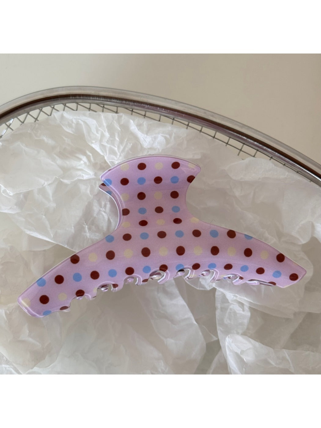 Beau pink hair clip with white polka dots displayed on a flat surface